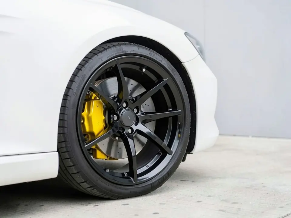AI-generated sample: the same wheel with a glossy yellow brake caliper behind the black spokes