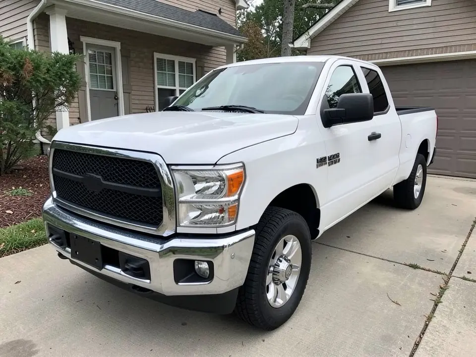 AI-drawn sample: a white pickup truck seen from the front left corner, with a chrome front bumper and chrome grille surround, parked in a driveway beside a house