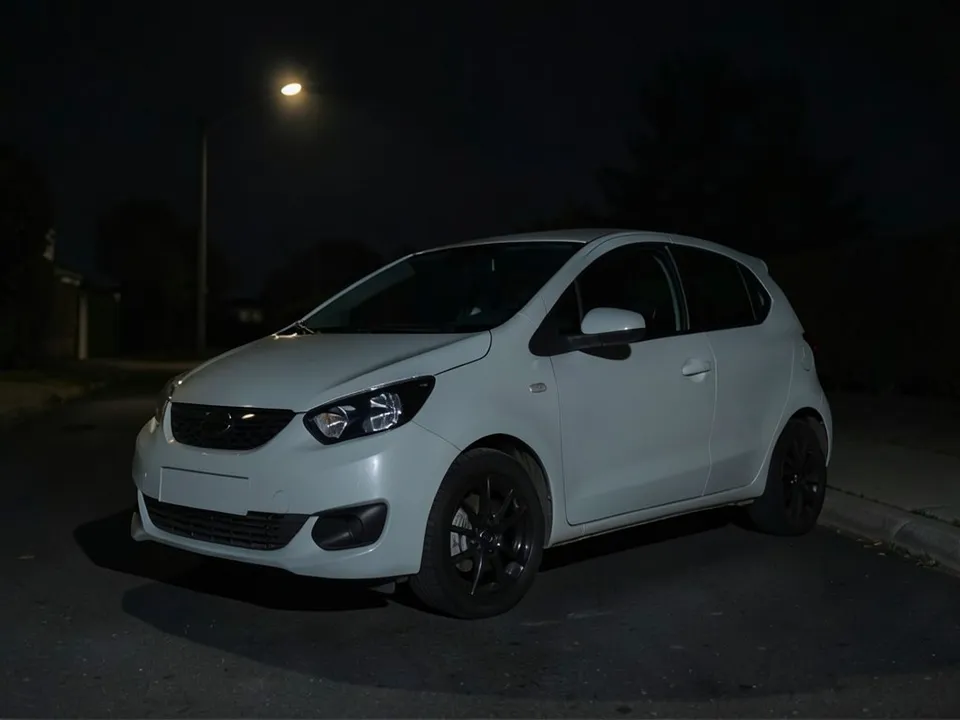 AI-drawn sample: a plain light gray hatchback with black wheels on a dark street at night