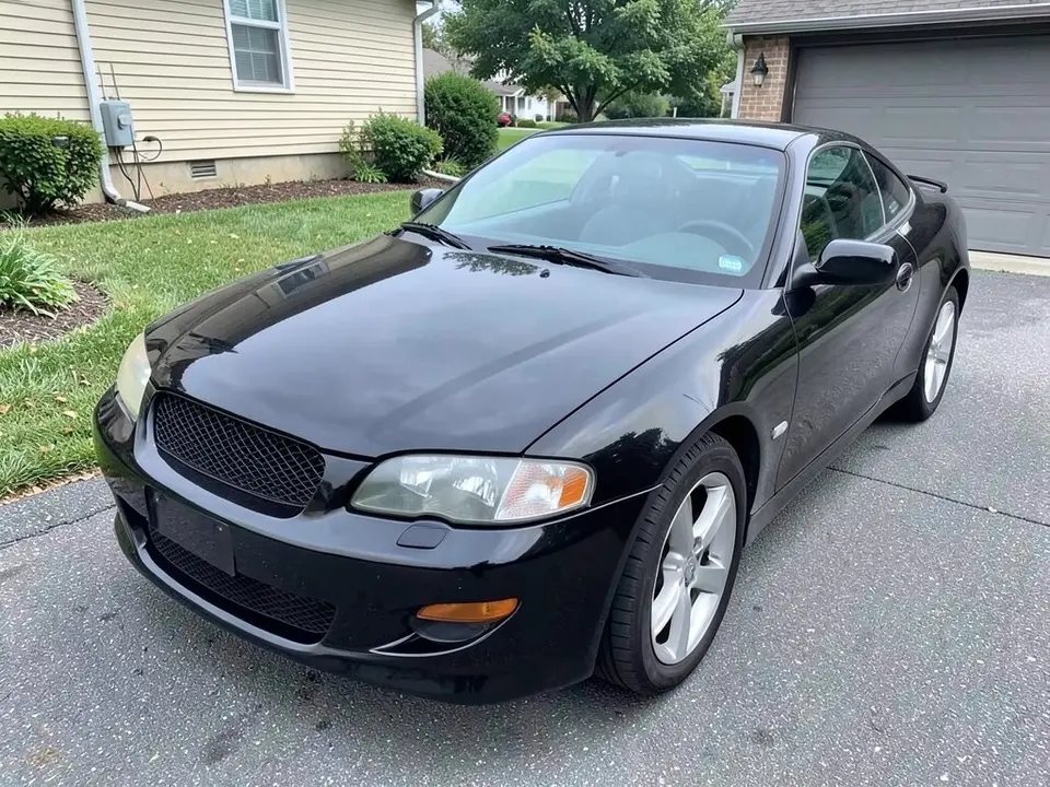 AI-drawn sample: a black two-door coupe seen from the front left corner, parked in a driveway beside a house