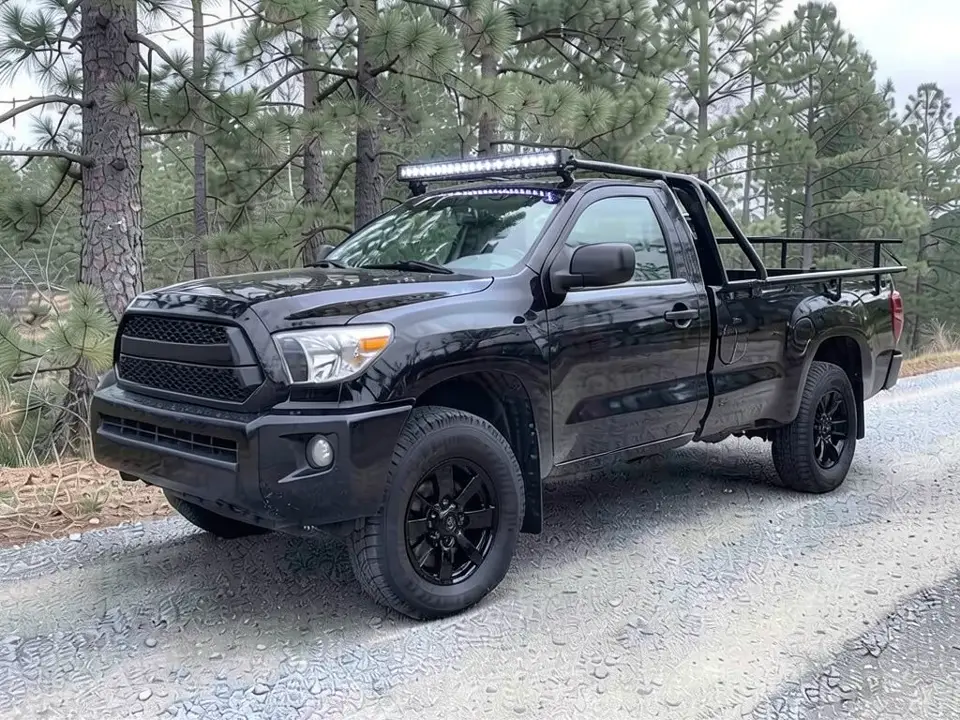 AI-drawn sample: the same pickup with gloss black wheels, low rails on the bed and a tube hoop holding an LED light bar above the windshield