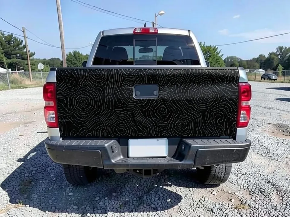 AI-drawn sample: the same tailgate wrapped matte black with gray contour lines